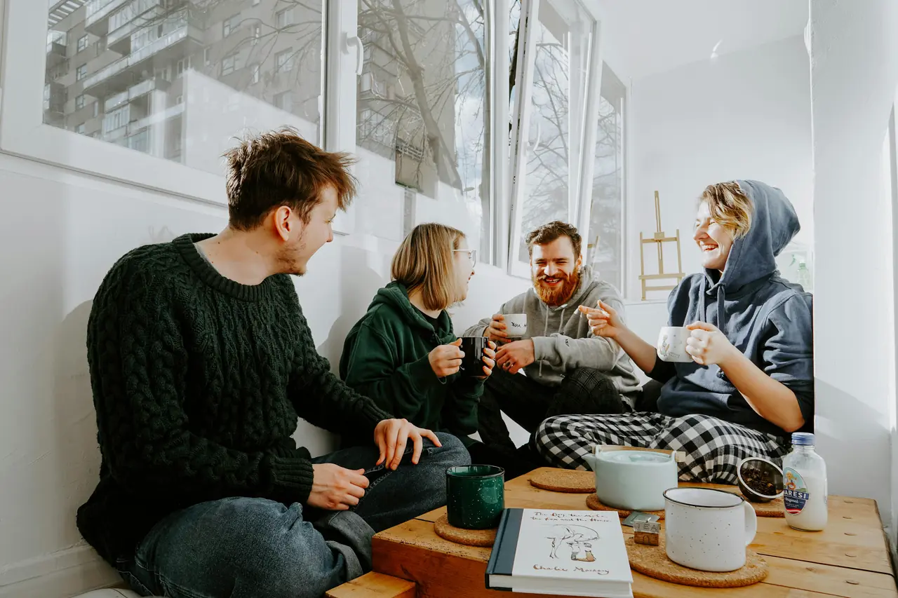 Four friends chatting over tea and coffee in a bright room