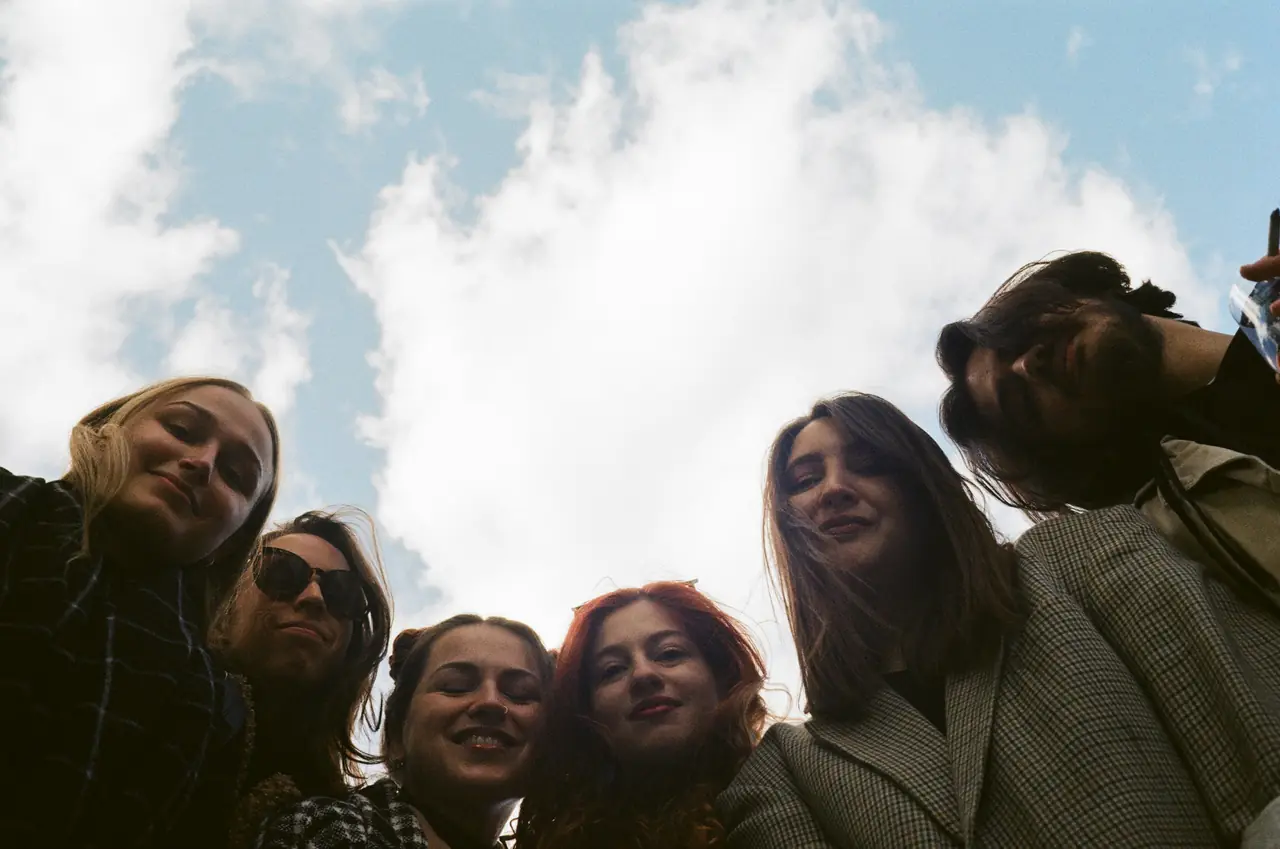 Friends taking a selfie from below against a bright sky